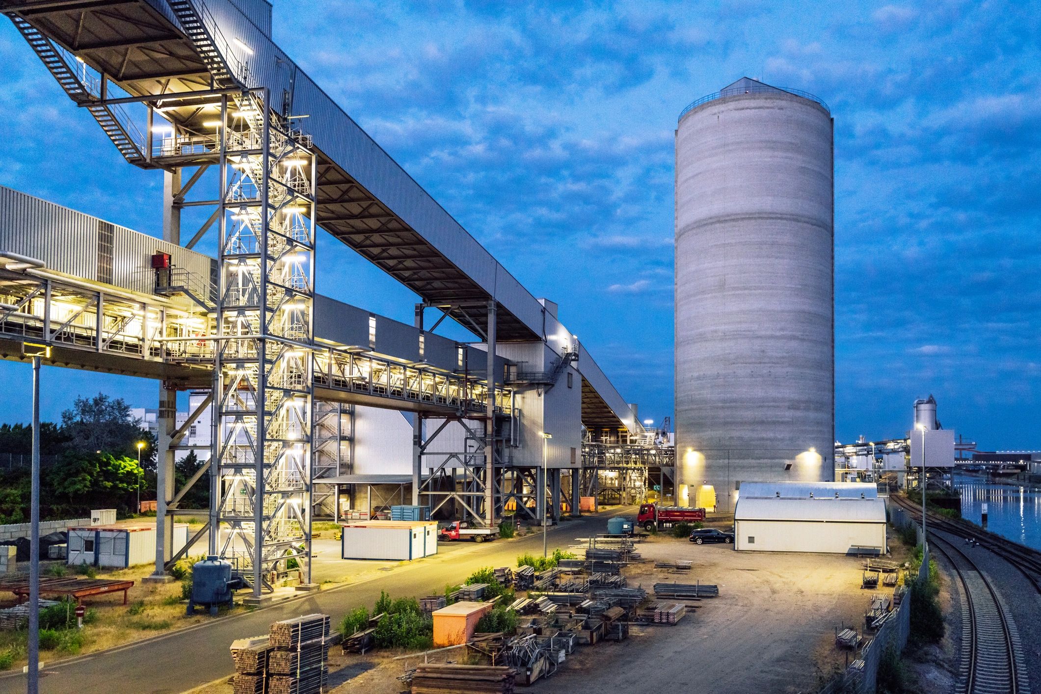 Industrial bulk storage facility with large silo at dusk